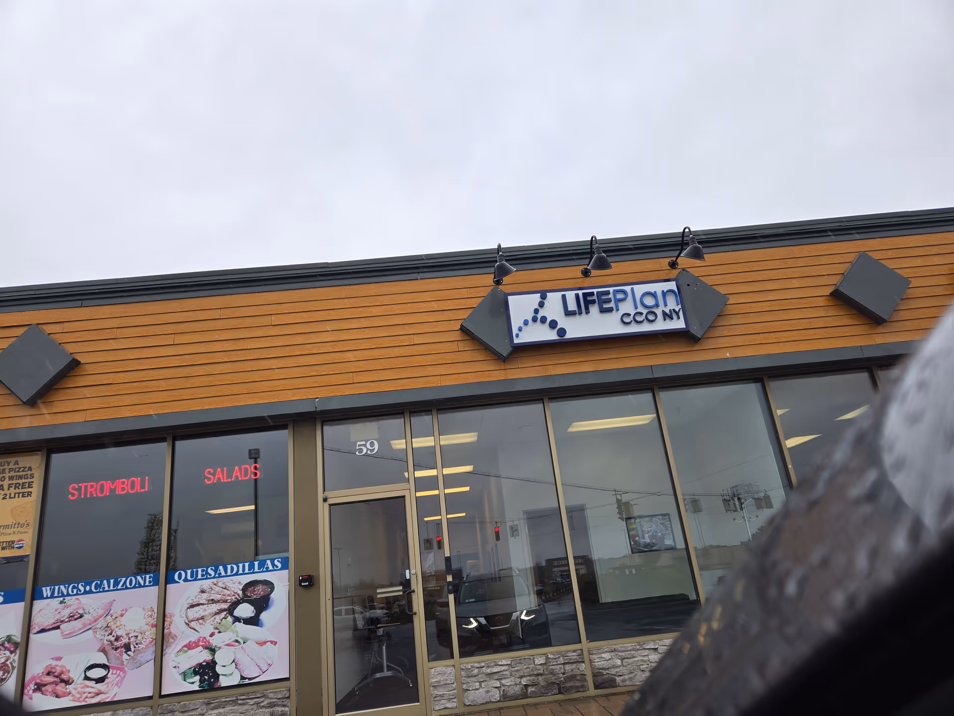 Exterior view of LIFEPlan CCO NY Plattsburgh building with glass storefront and signage.