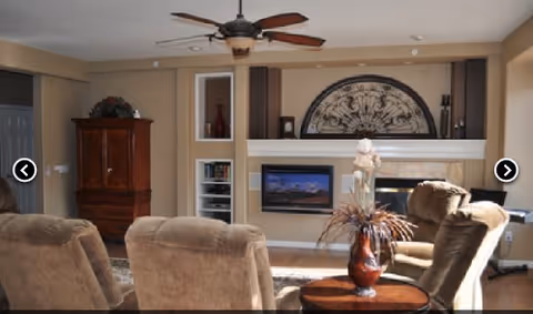 Cozy living room with beige seating, fireplace, and mounted TV.
