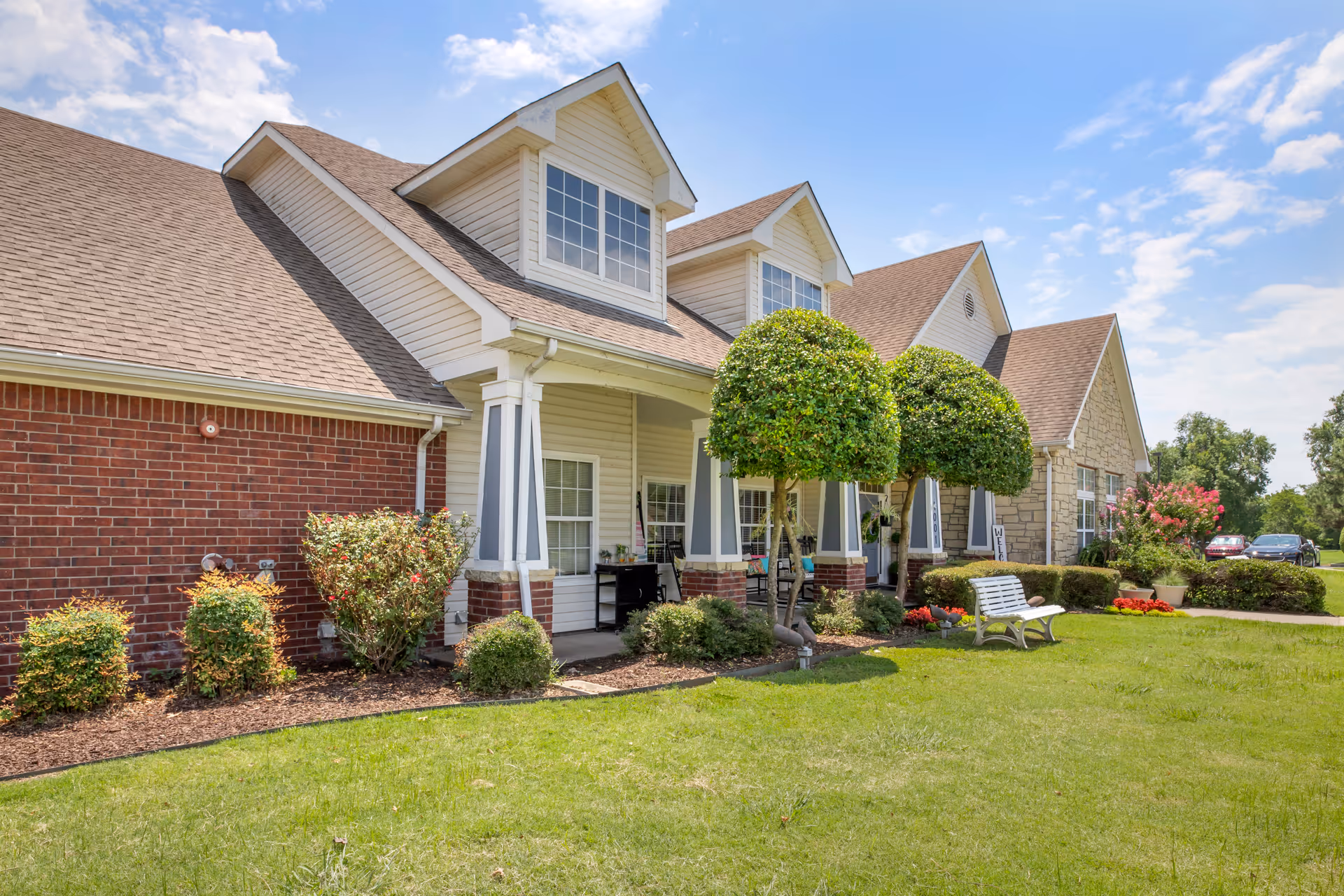 Exterior view of Brookdale Broken Arrow senior living facility with porch and manicured lawn.