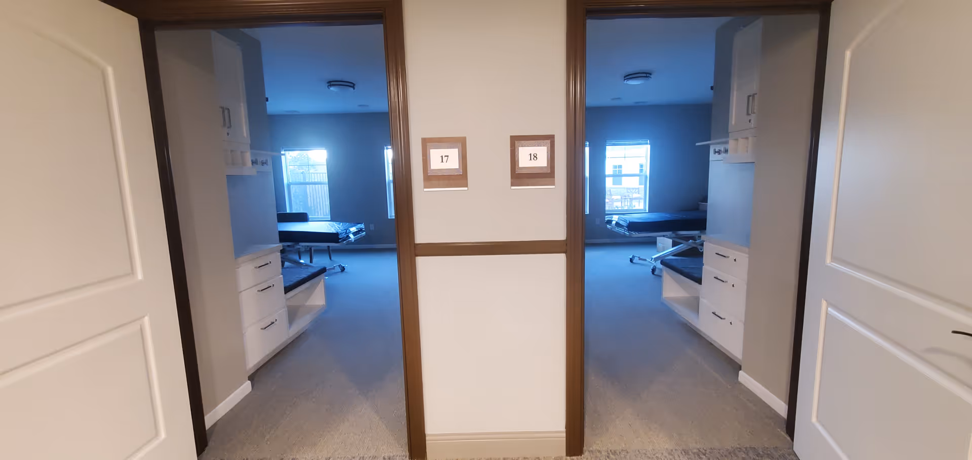 Central hallway with two open doorways revealing bedrooms and numbered signs 17 and 18.
