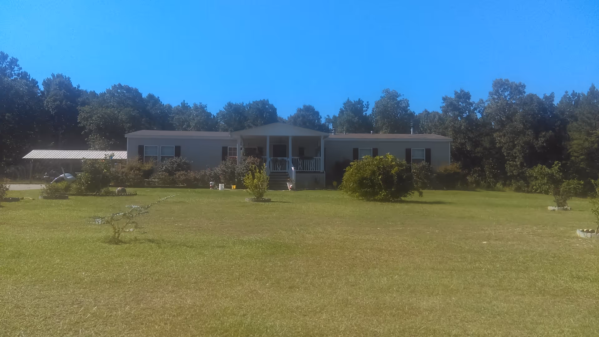 Single-story senior living facility with a front porch and expansive lawn.