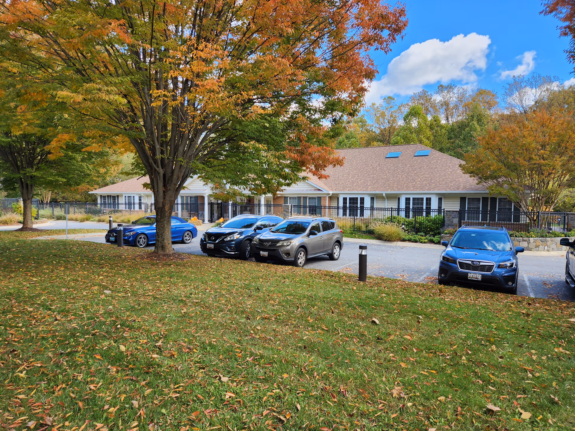Exterior view of Meadows 1639 facility with parked cars and autumn trees.