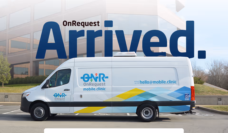White OnRequest mobile clinic van in a parking lot beside a modern office building.