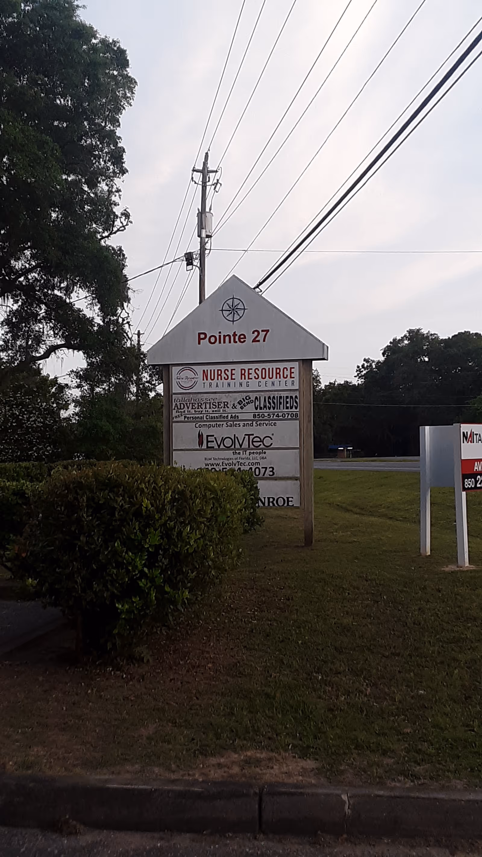 Outdoor sign on a roadside displays Pointe 27 and Nurse Resource Training Center information.
