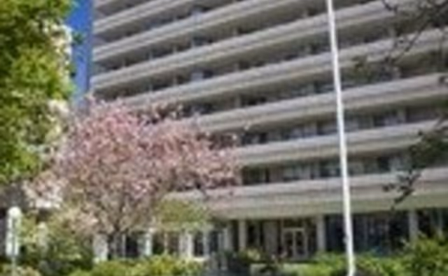 Exterior view of Piedmont Gardens, a multistory senior living facility with balconies and landscaped entrance.