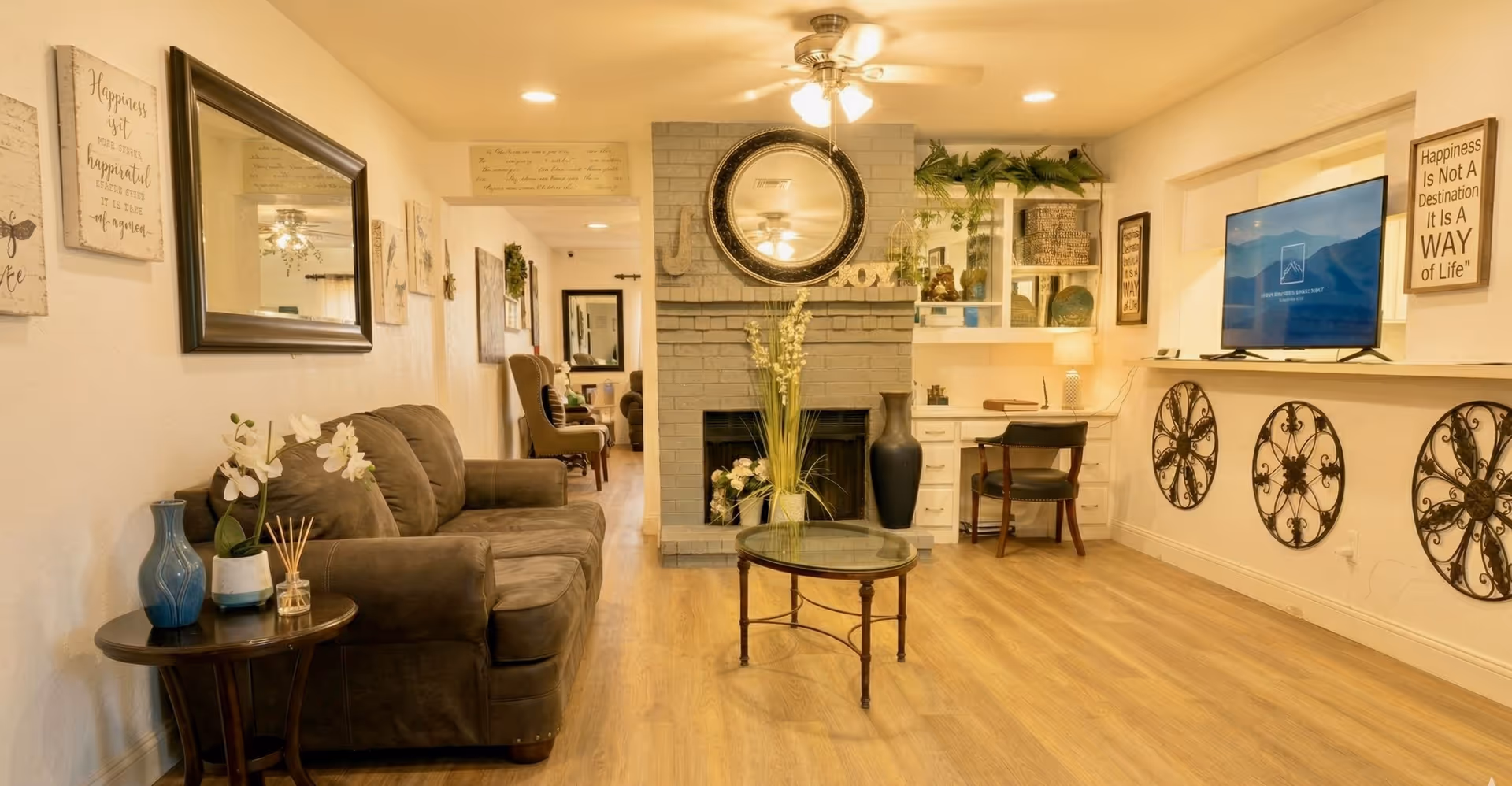 Cozy senior-living living room with sofa, fireplace, TV, and shelves.