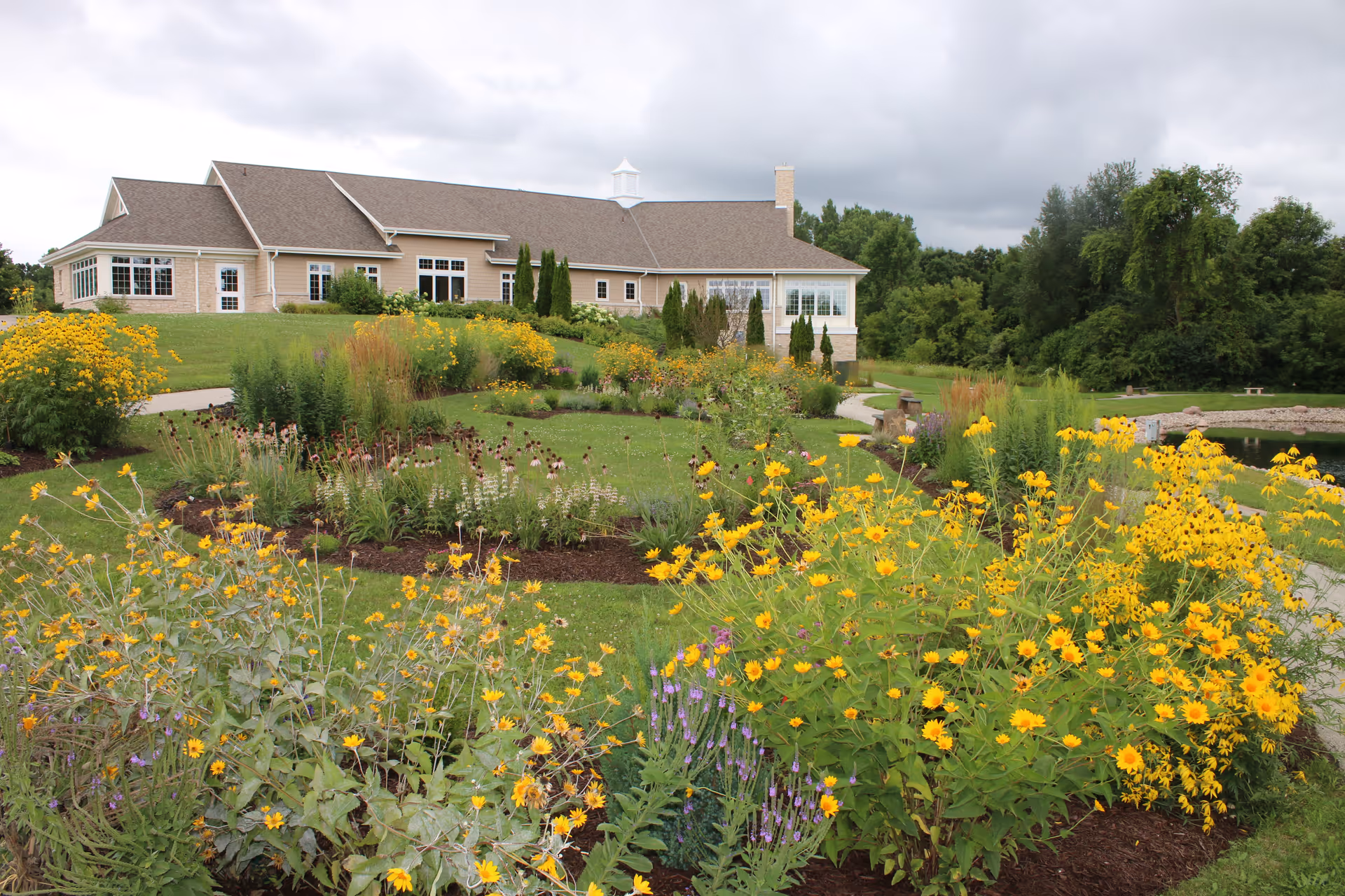 Outdoor view of a single-story building with a colorful flower garden in front.