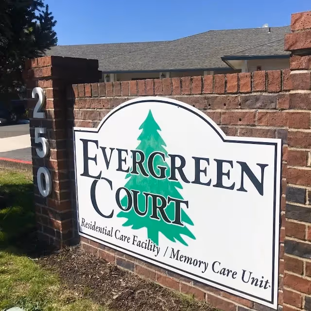 Brick entrance sign reads Evergreen Court Residential Care Facility / Memory Care Unit.
