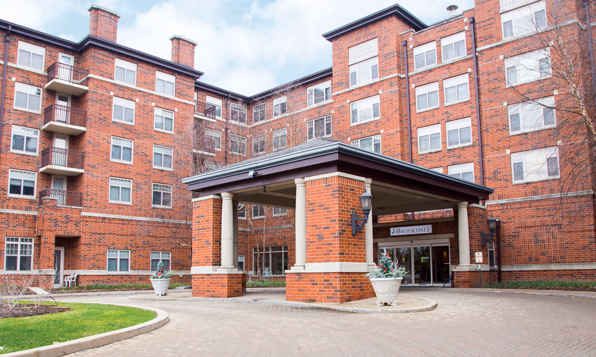 Brick senior living building with a covered entrance, columns, and Brookdale sign.