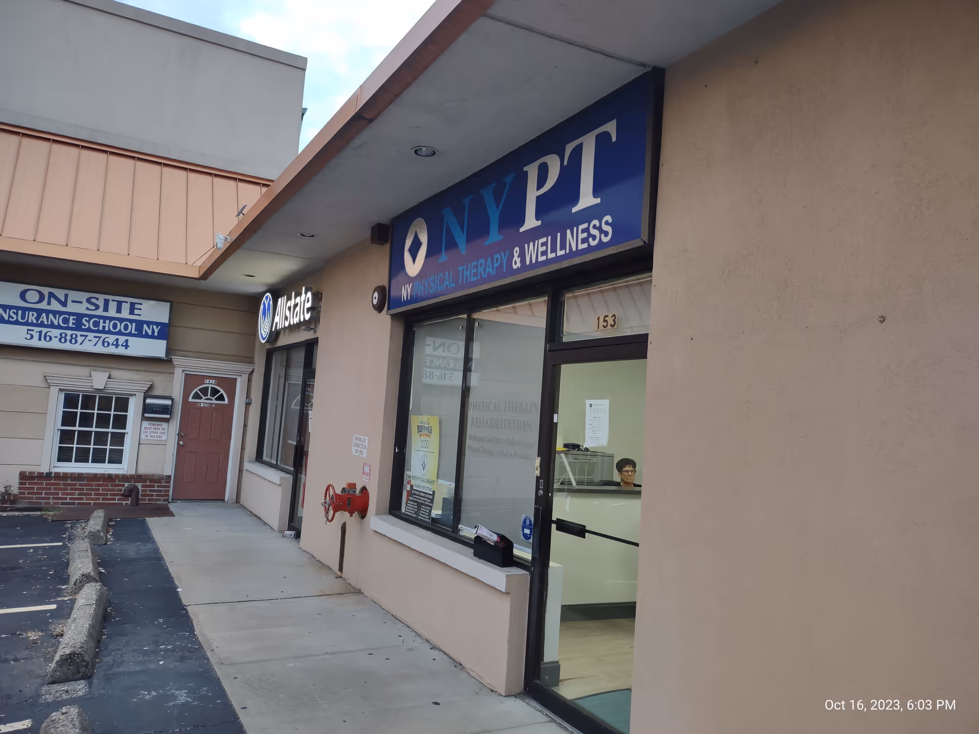 Storefront exterior with a blue sign for physical therapy and wellness.