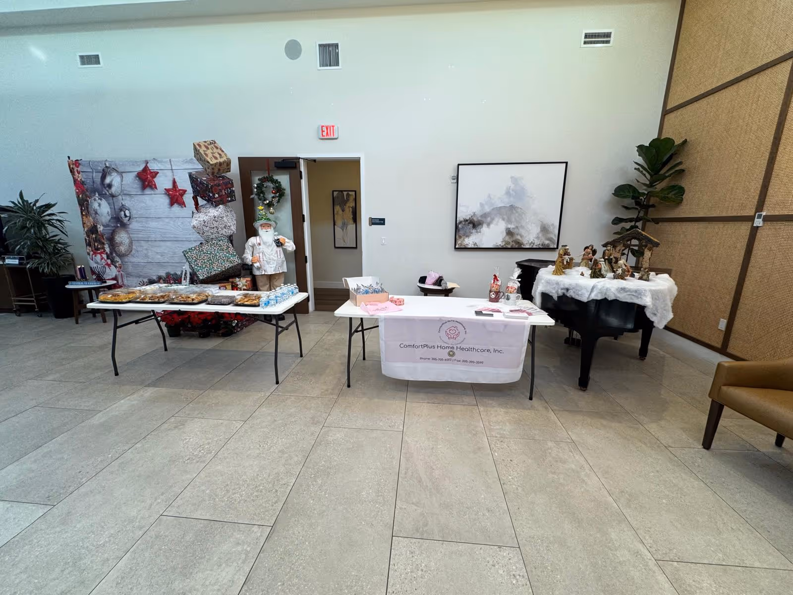 Indoor ComfortPlus lobby with holiday display, tables of treats, and a staff member.