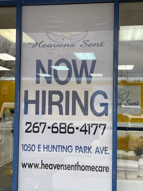 Window storefront displays a NOW HIRING sign for Heavens Sent Home Care LLC.