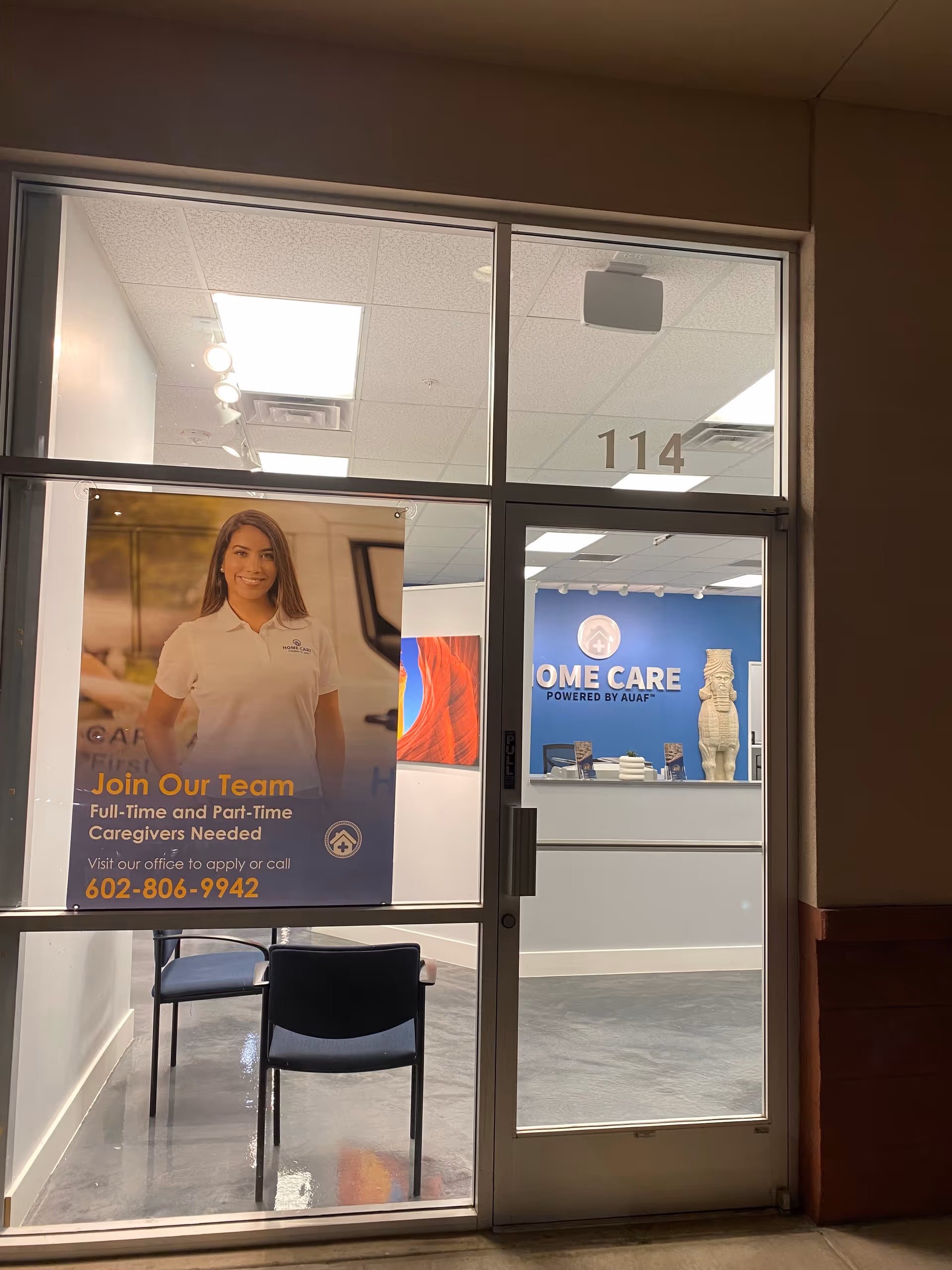 Glass door entrance to Home Care Arizona lobby with a poster and reception desk.