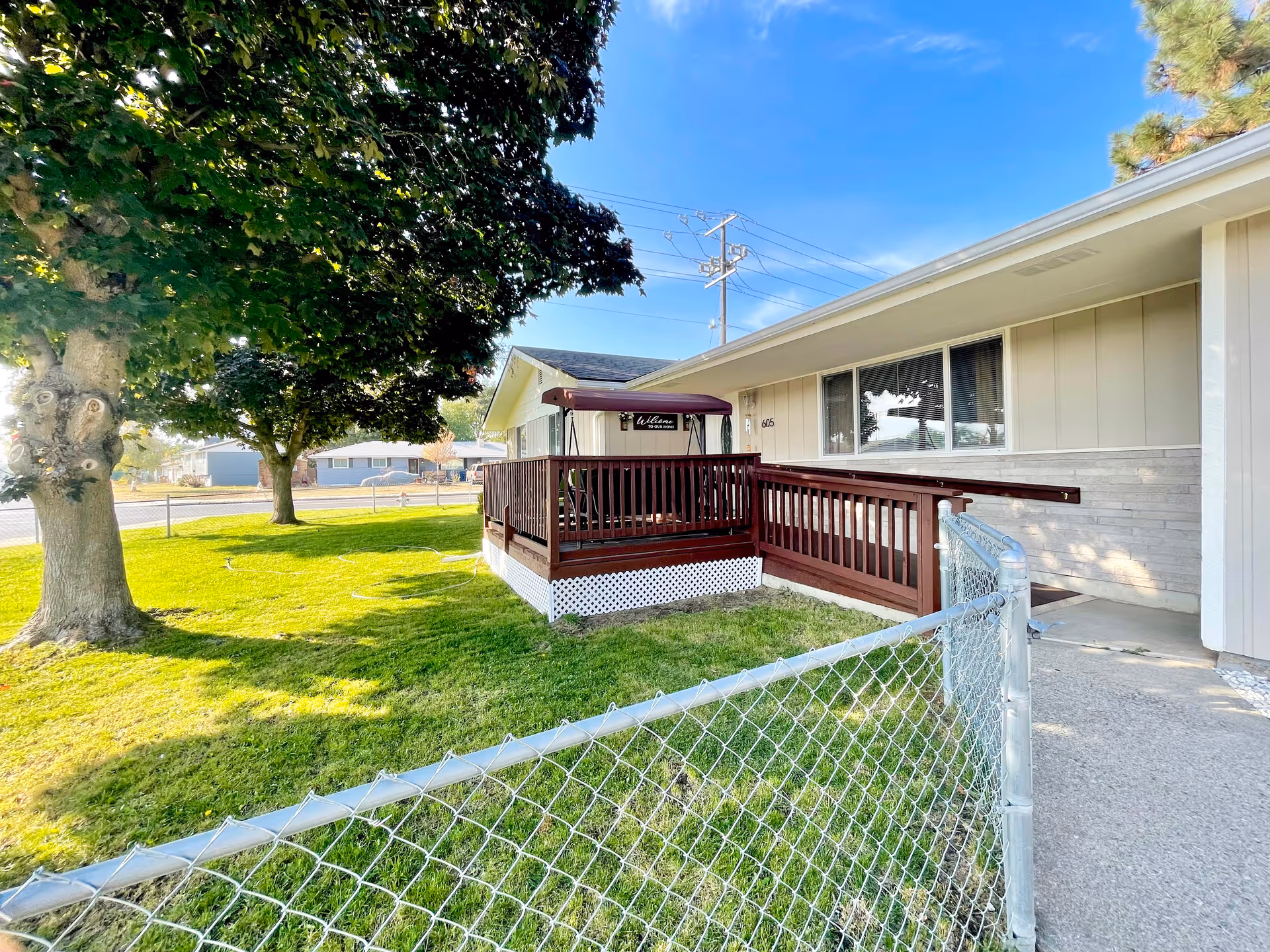 Exterior view of Graceful Hearts Adult Family Home with a wooden porch and surrounding lawn.
