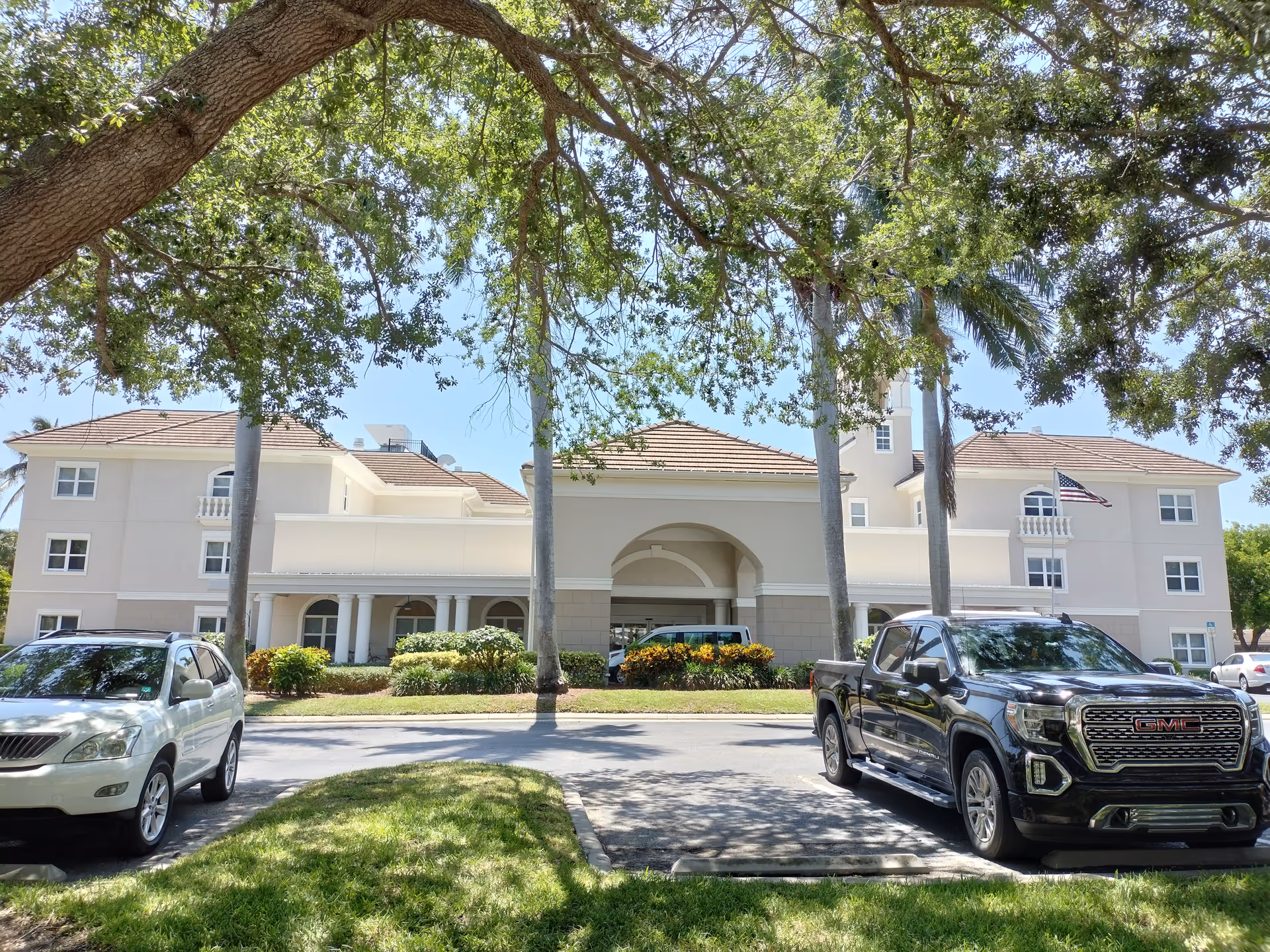Exterior view of Brookdale Bonita Springs building with palm trees and parked cars.