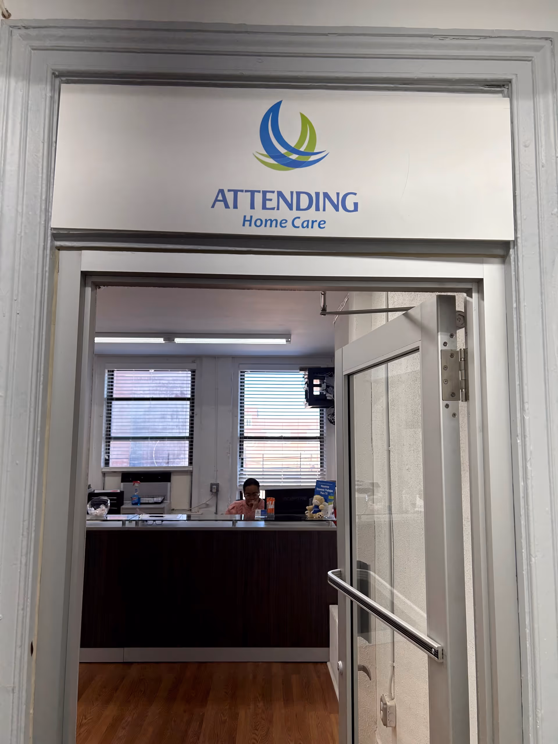 Interior reception area of Attending Home Care Bronx with counter and sign.