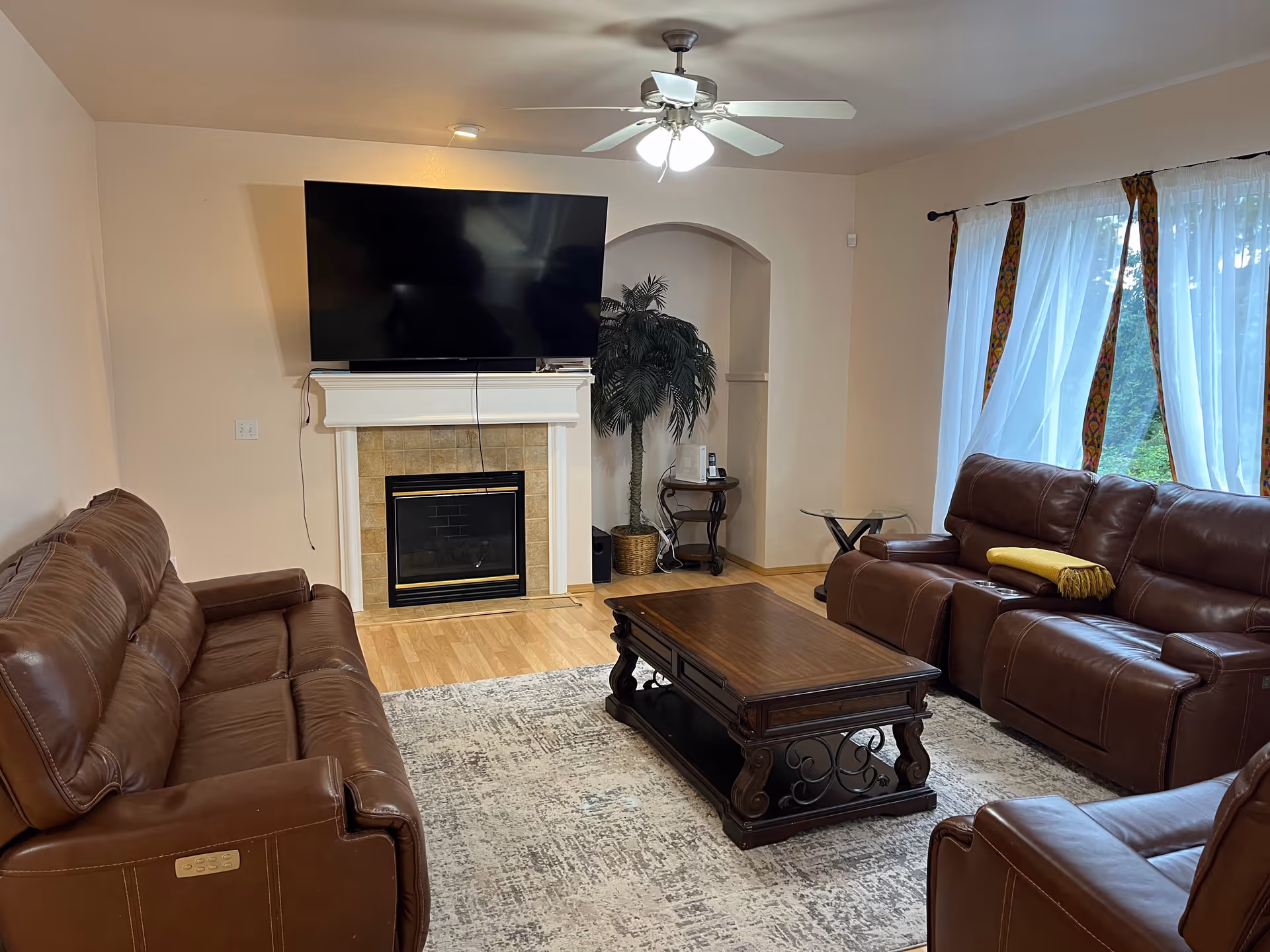 Living room with leather sofas, fireplace, and wall-mounted TV