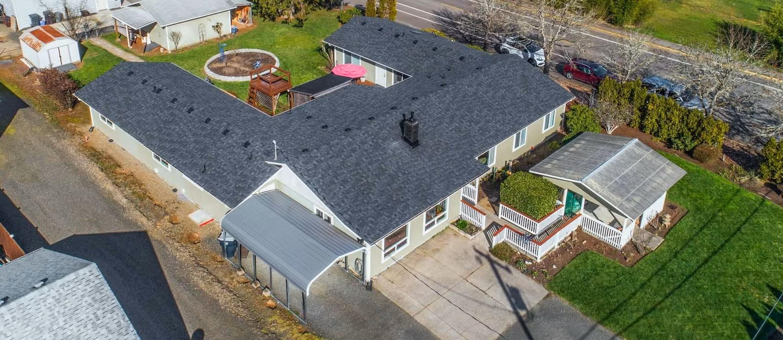 Aerial view of Country Comfort AFH, a single-story senior living home with dark roof and lawn.