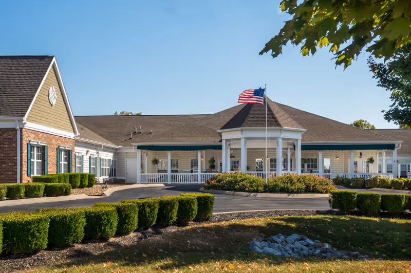 Front exterior of a senior living facility with a covered entrance and manicured landscaping.
