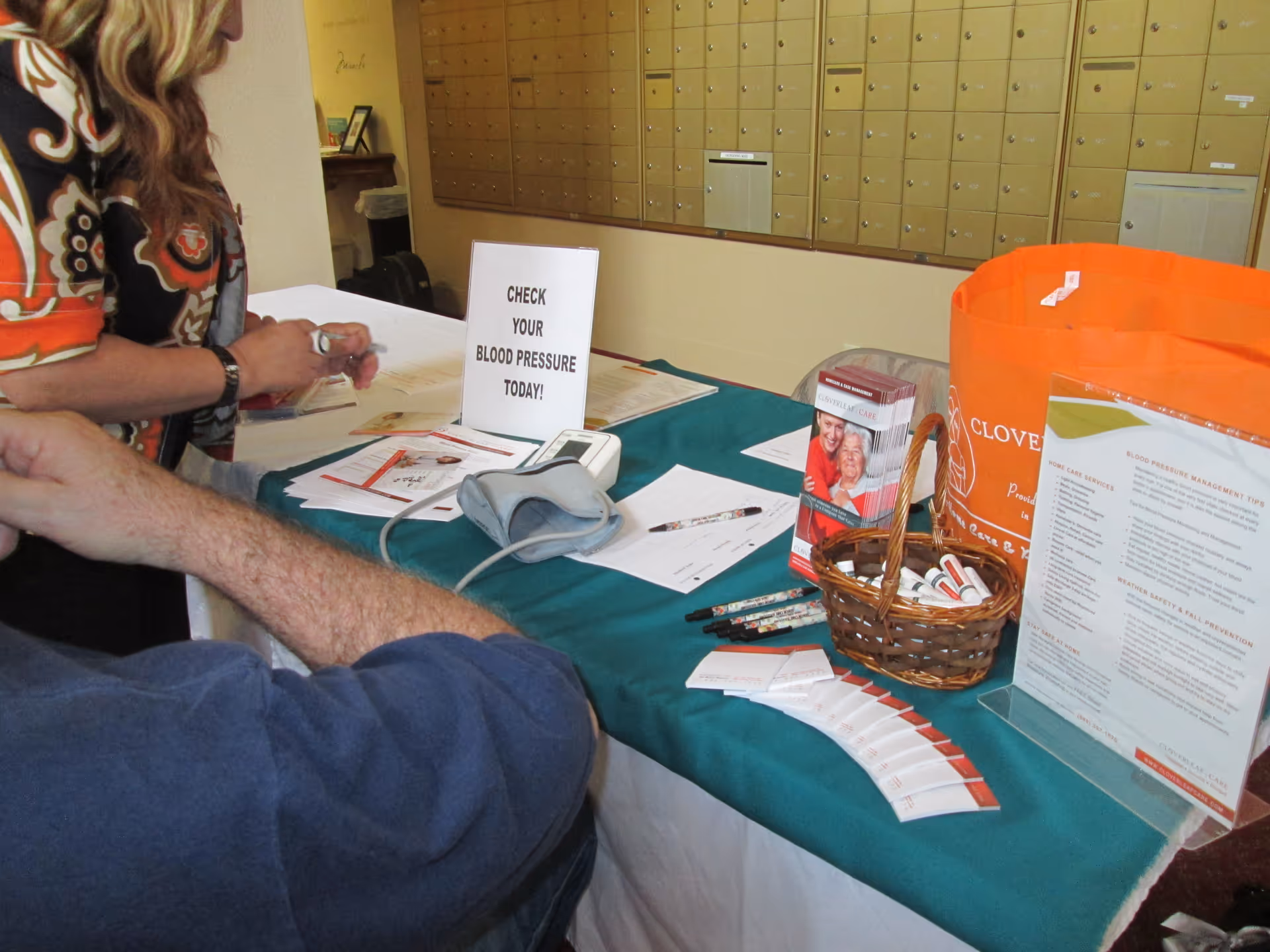 Blood pressure screening station set up on a table inside Cloverleaf Care lobby.