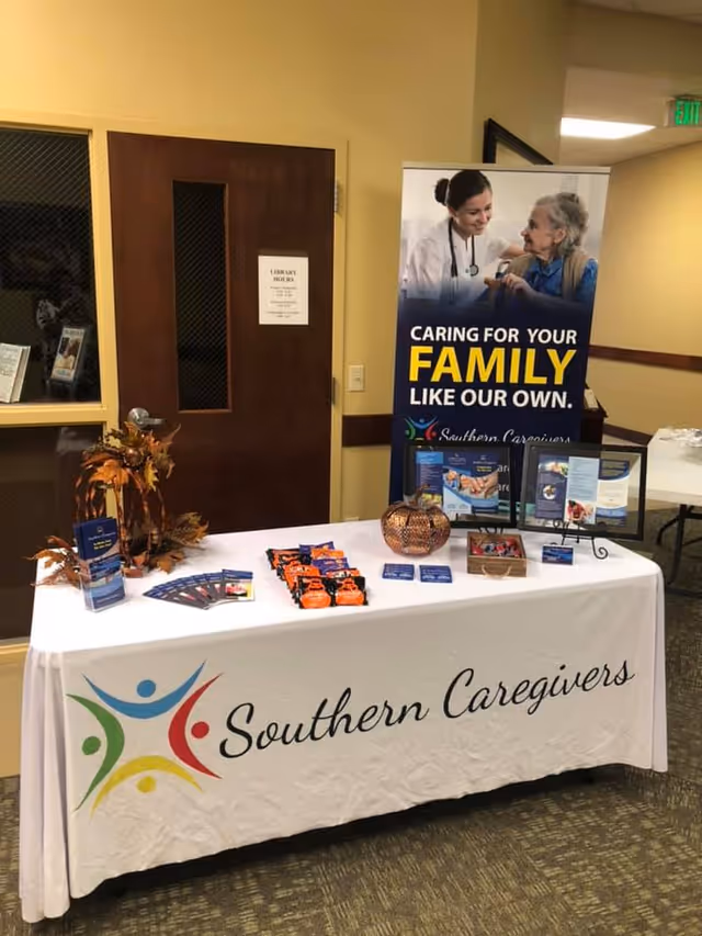 A display table with Southern Caregivers branding and brochures in a hallway.