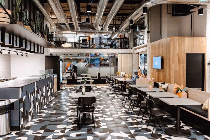 Modern dining area in a senior living facility with patterned tile floor and seating.