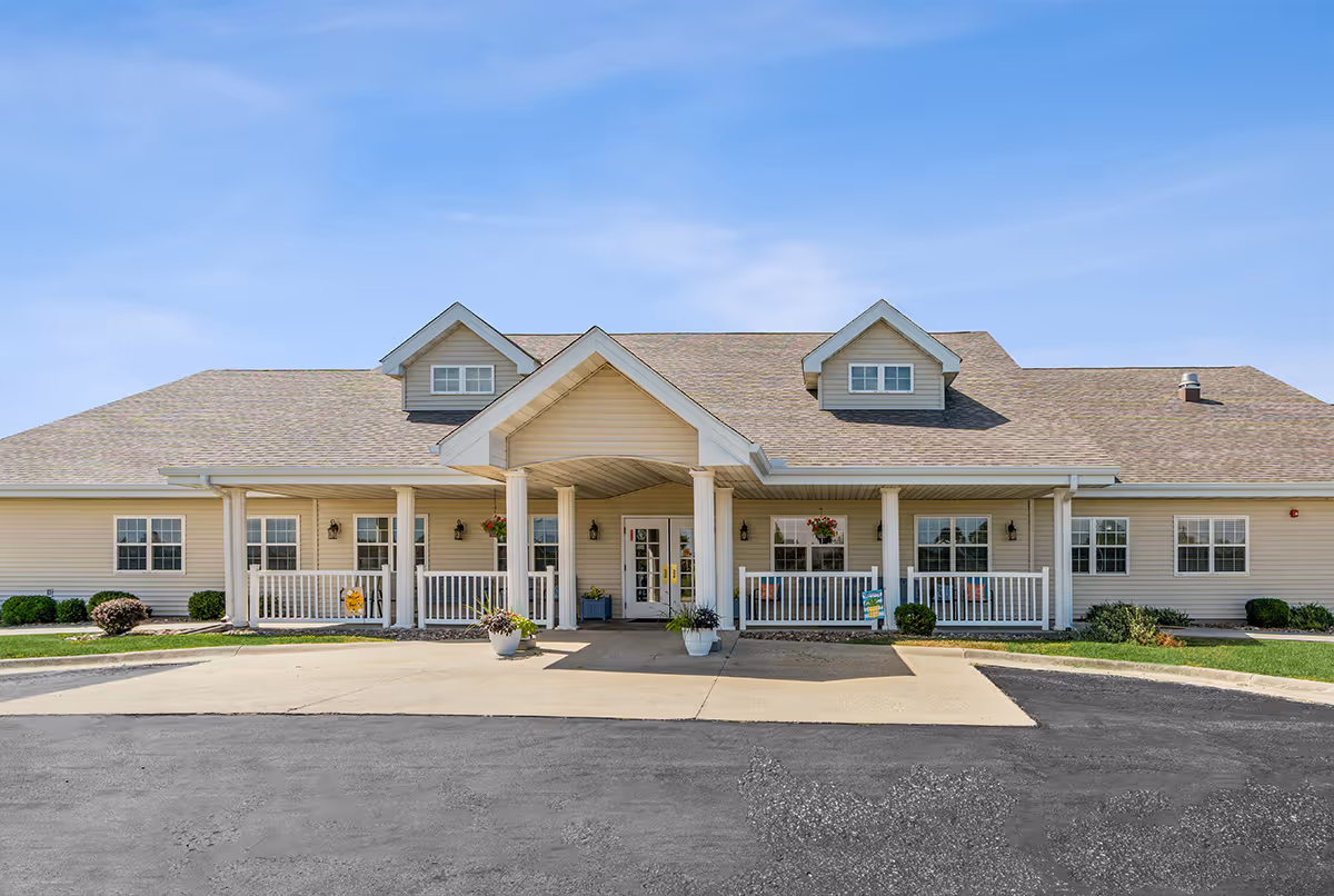 A single-story senior living facility exterior with a central entrance and covered porch.