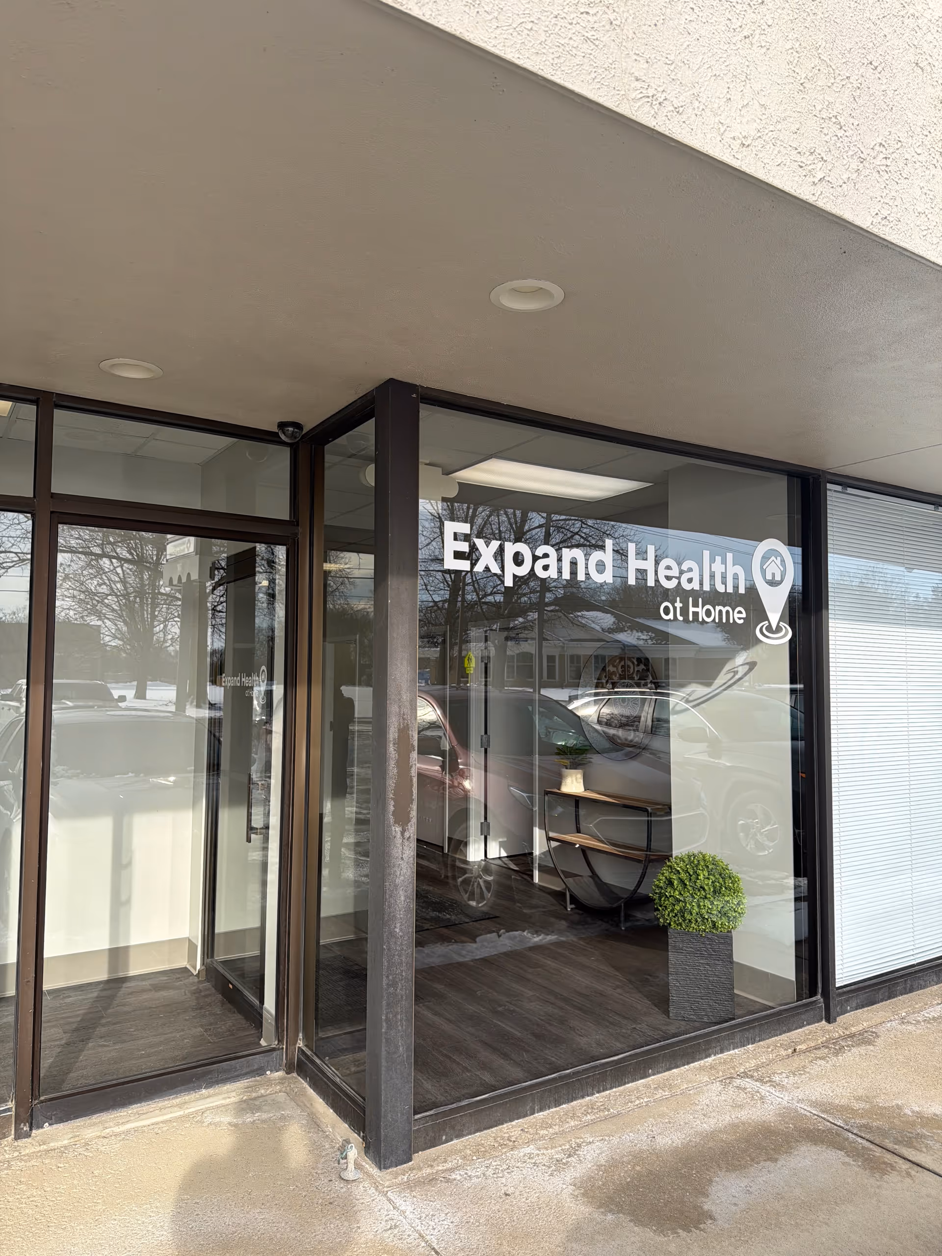 Exterior view of Expand Health at Home entrance with glass doors and signage.