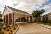 Front view of The Villa at Mountain View with brick columns, curved driveway, and covered entrance.