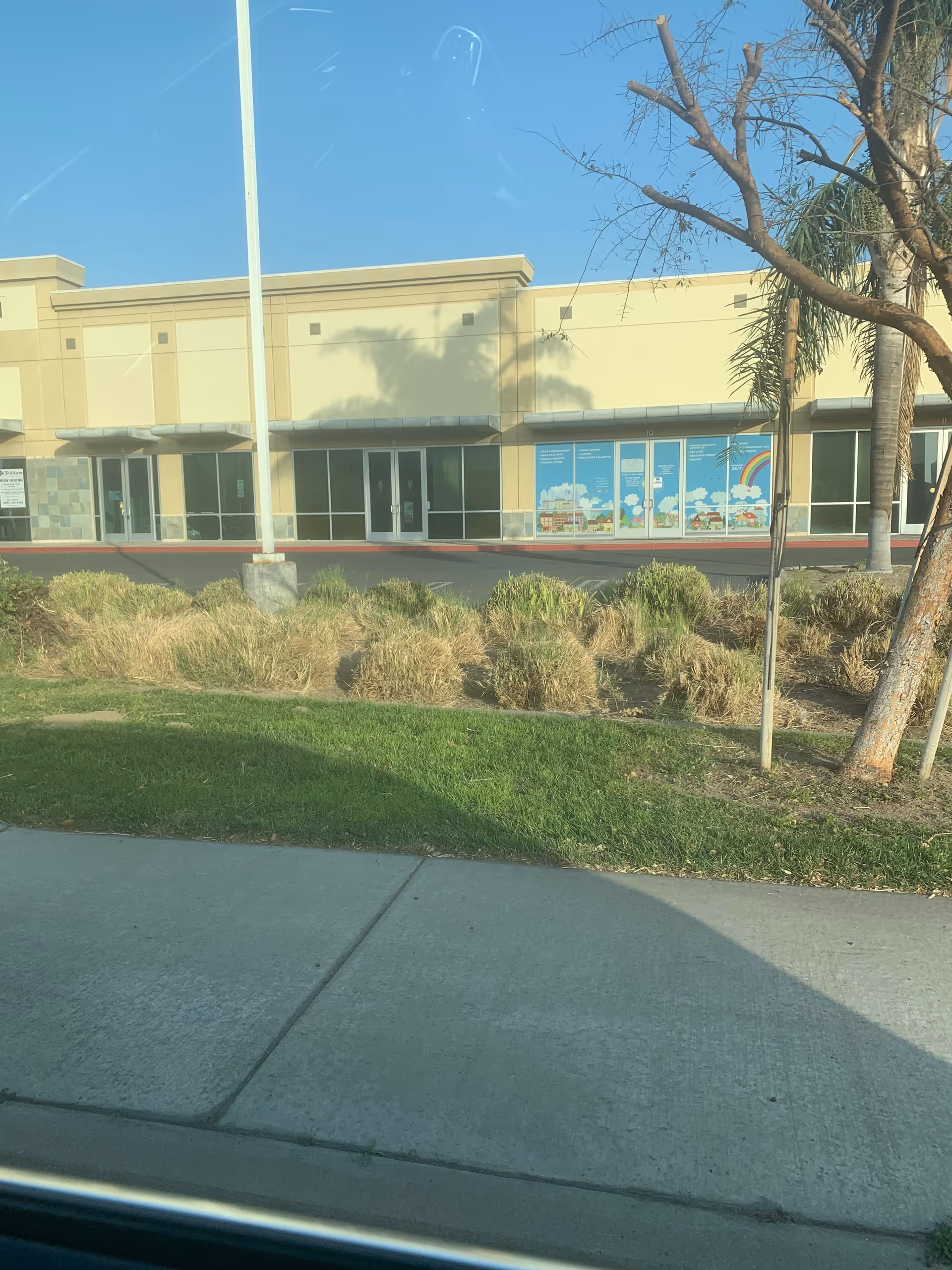 Exterior view of A Rainbow of Care, HC facility with beige walls and glass storefront.