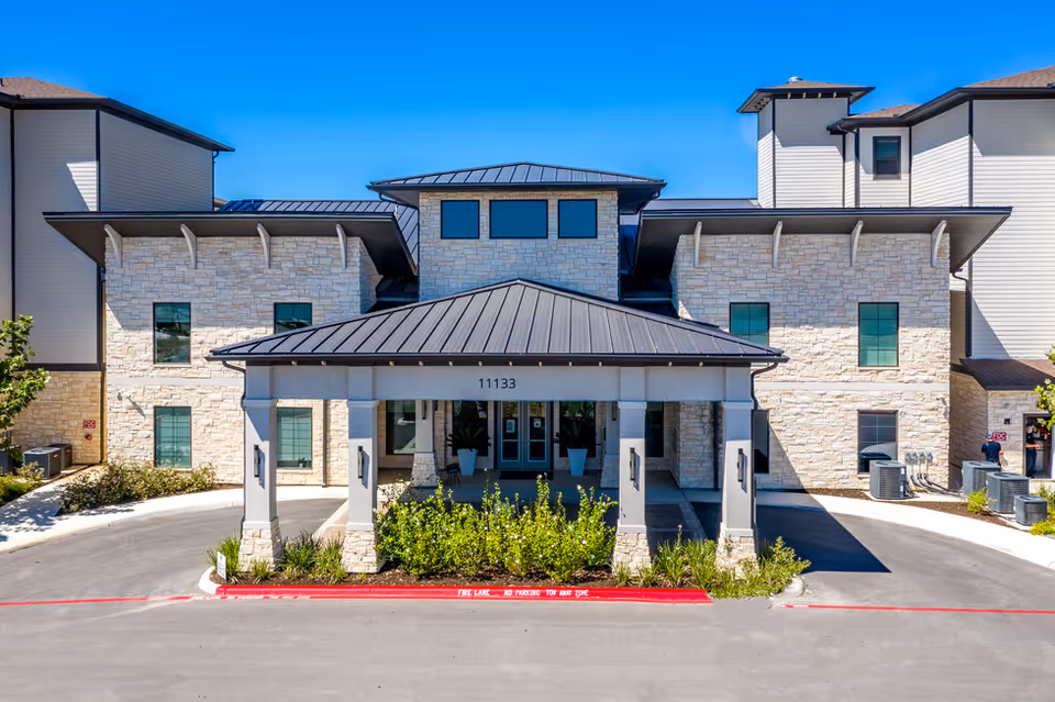 Solea Alamo Ranch exterior with stone facade, covered entrance, driveway, and landscaped front.