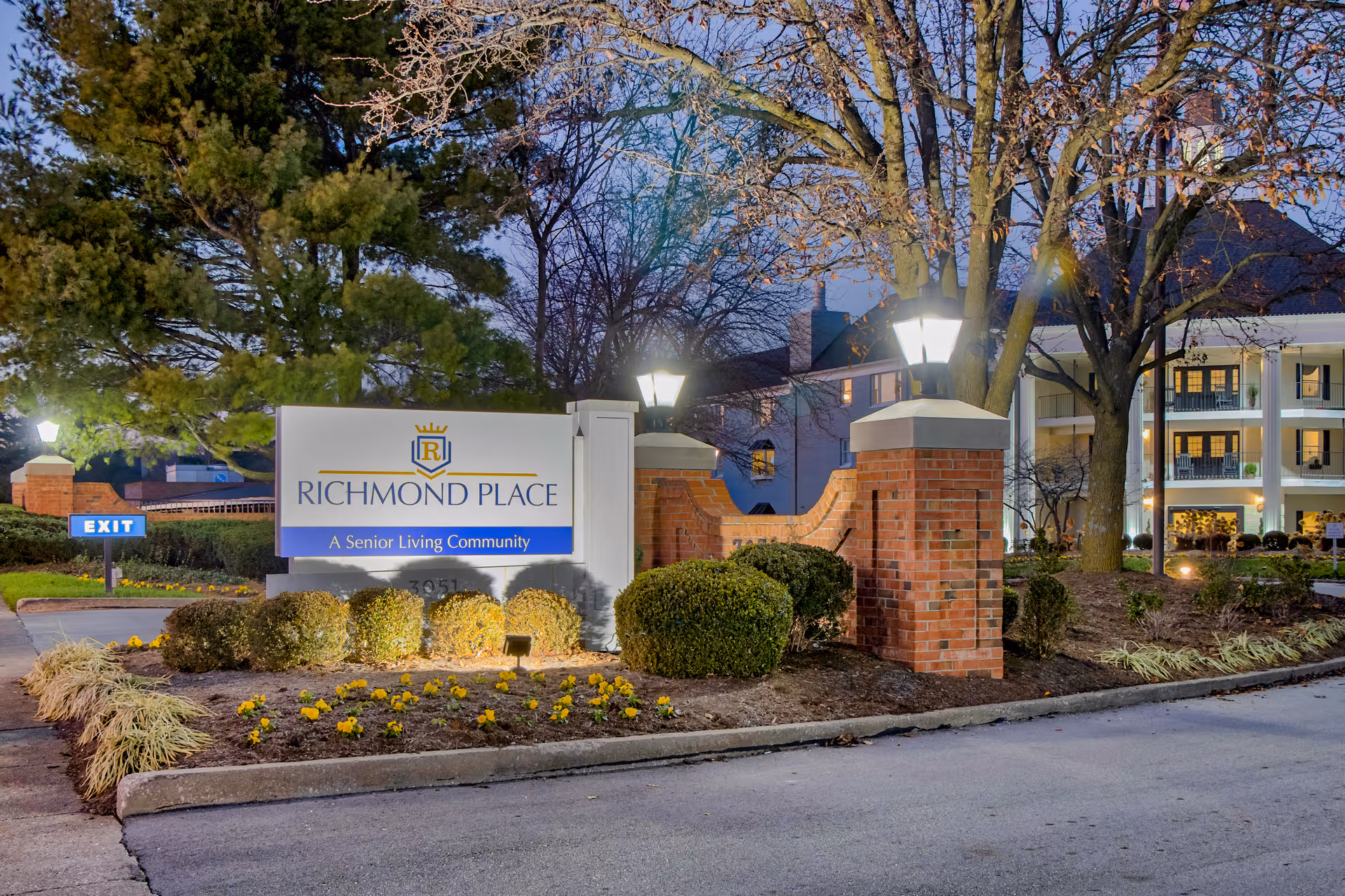 Exterior view of the Richmond Place senior living community sign and entrance with landscaping.