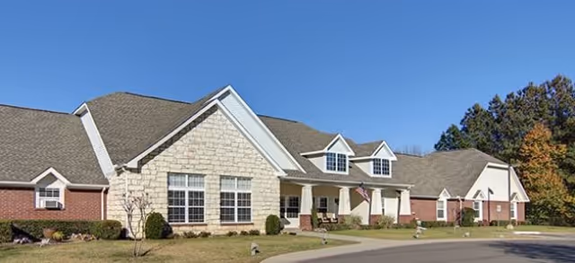 Sunny exterior of Brookdale Texarkana senior living building with stone facade and landscaping.