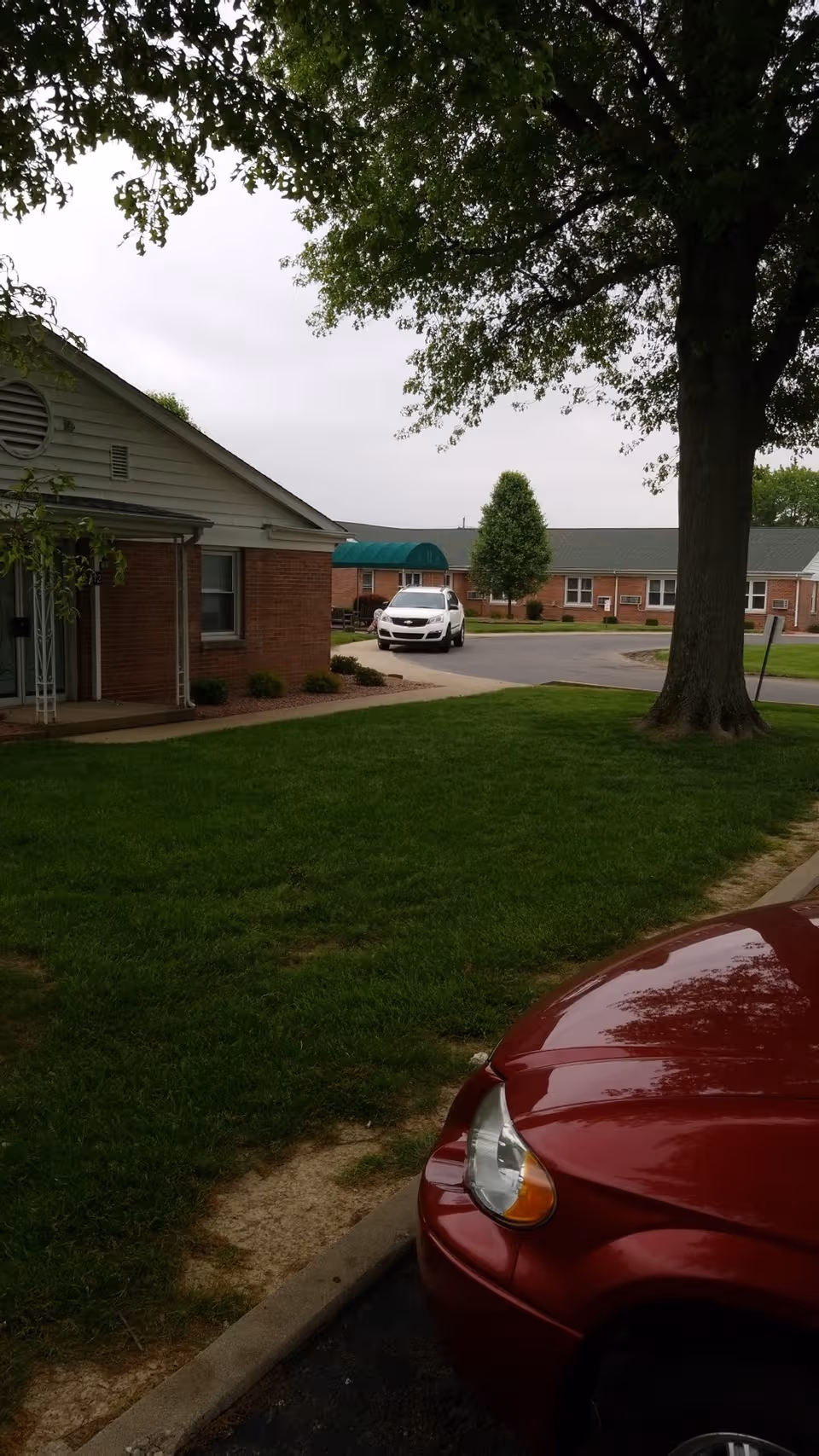 Miller's Merry Manor exterior with brick buildings, trees, and a parked car.