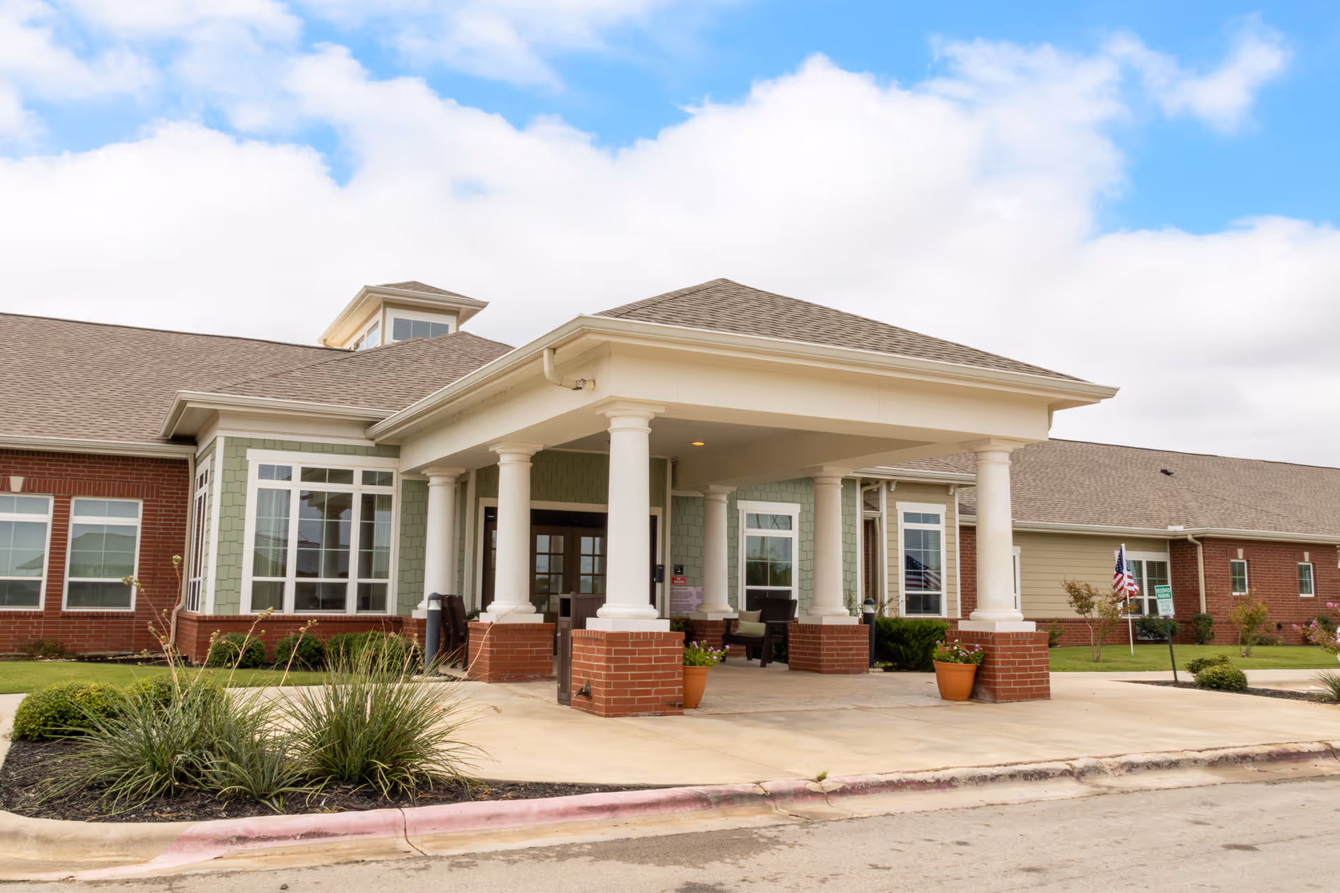 Exterior entrance of Lyndale Abilene Senior Living with white columns and covered porch.