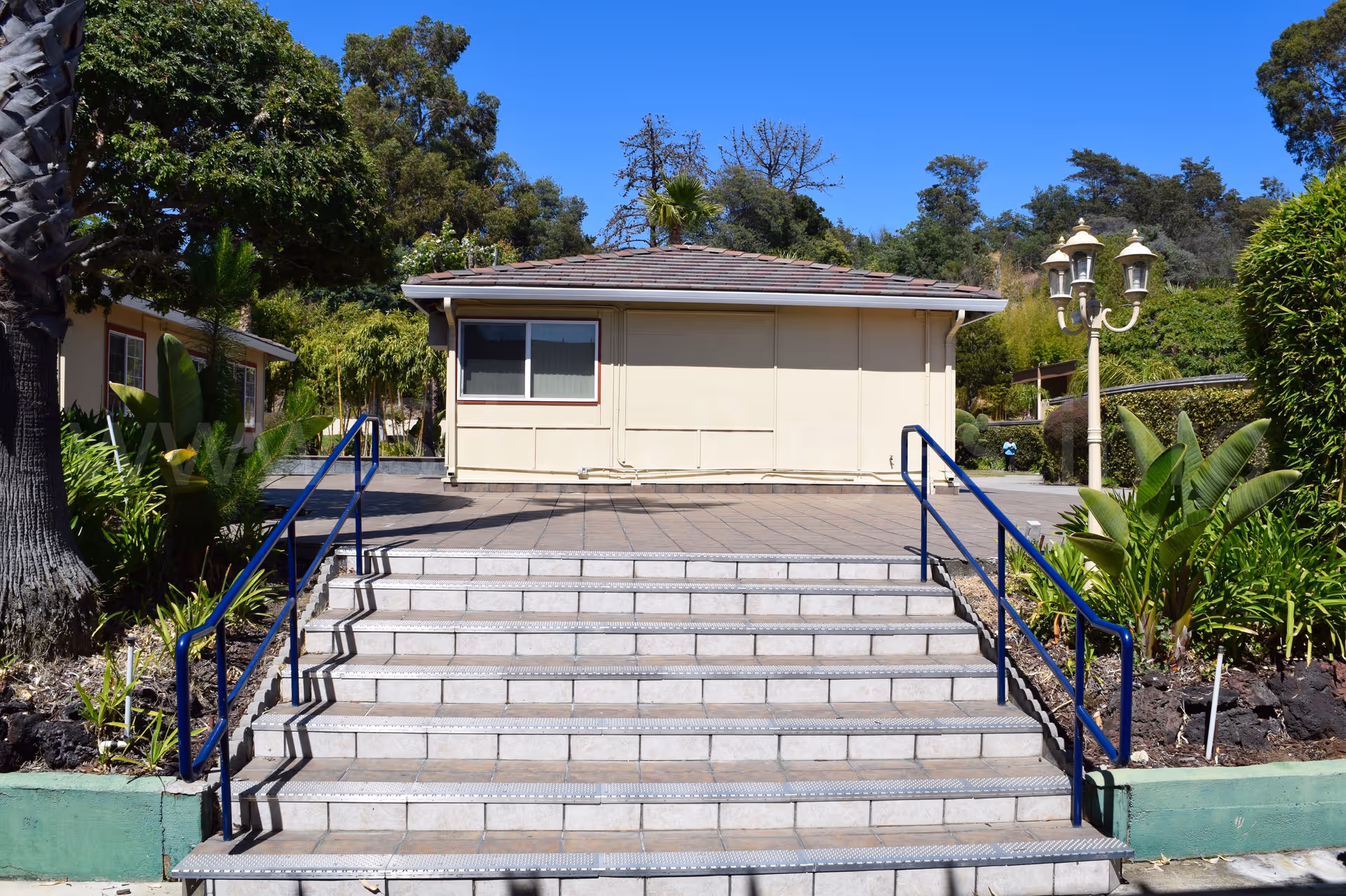 Front view of a single-story retirement center building with steps and blue railings.