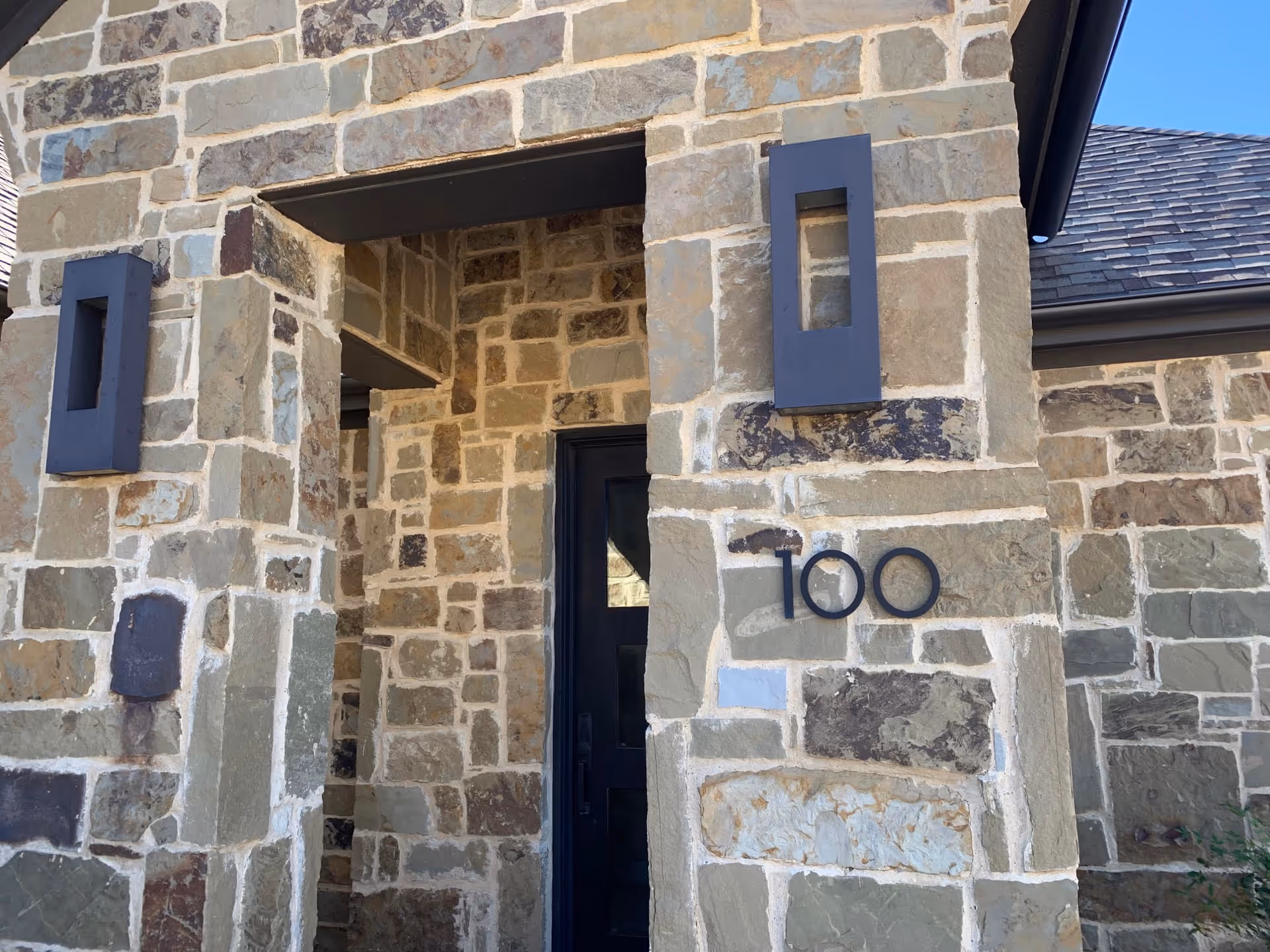 Stone building exterior showing a front entrance and the number 100.