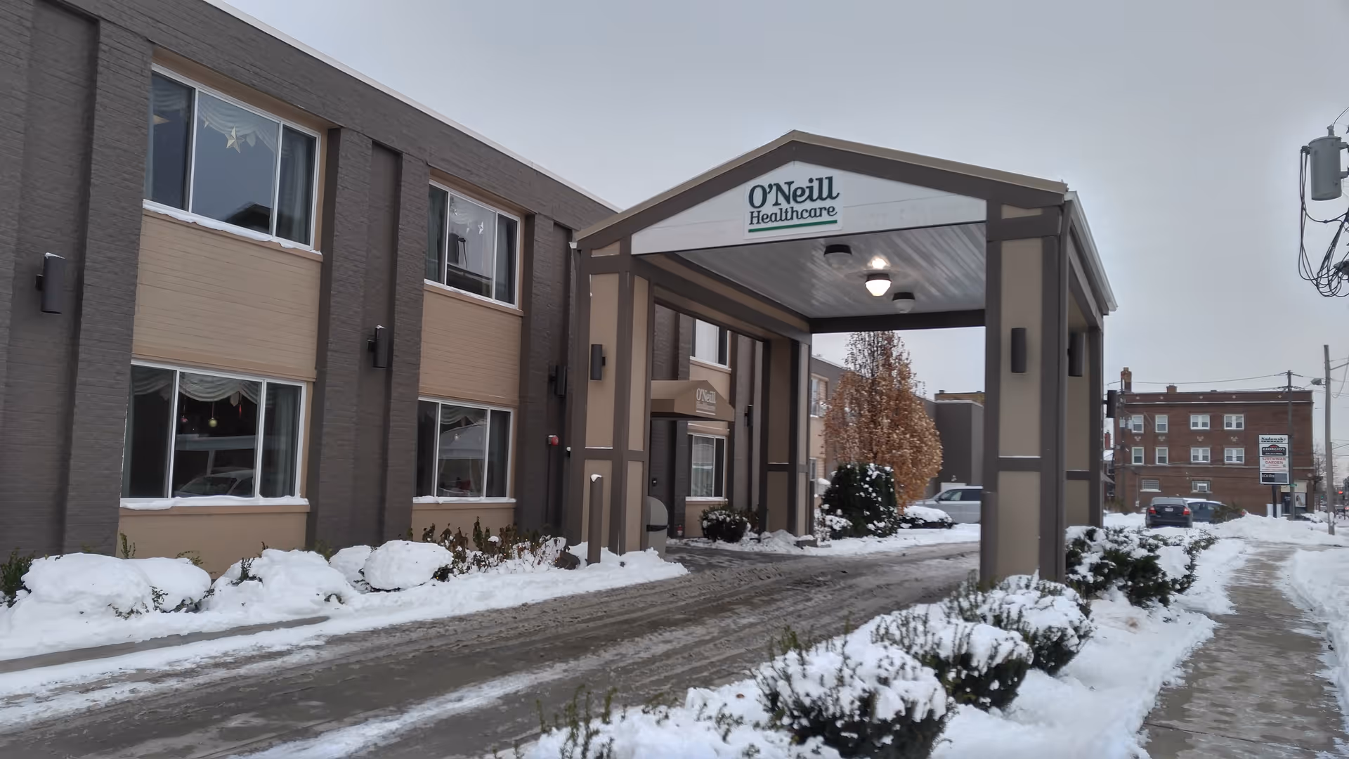Snowy exterior of O'Neill Healthcare Lakewood with a covered entrance and driveway.