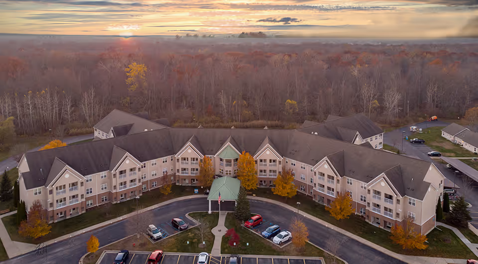 Aerial view of The Village of Lake Huron Woods, a senior living campus, with autumn trees.