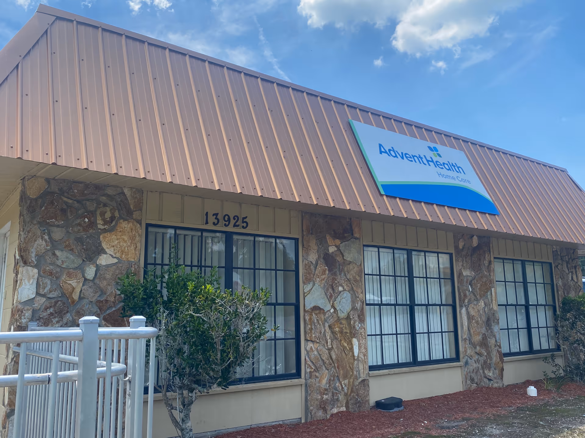 Exterior view of AdventHealth Home Care building with stone facade, windows, and signage.