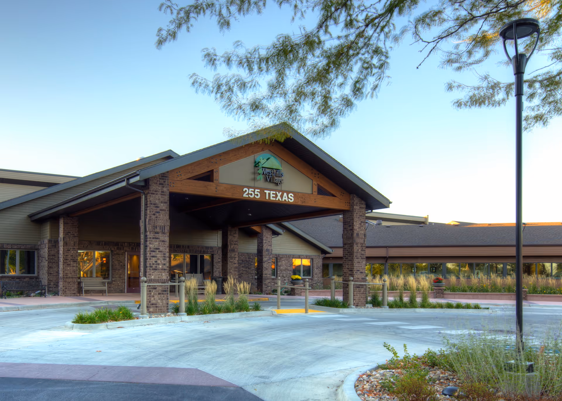 Exterior view of Westhills Village entrance with brick columns and a drive-up drop-off.