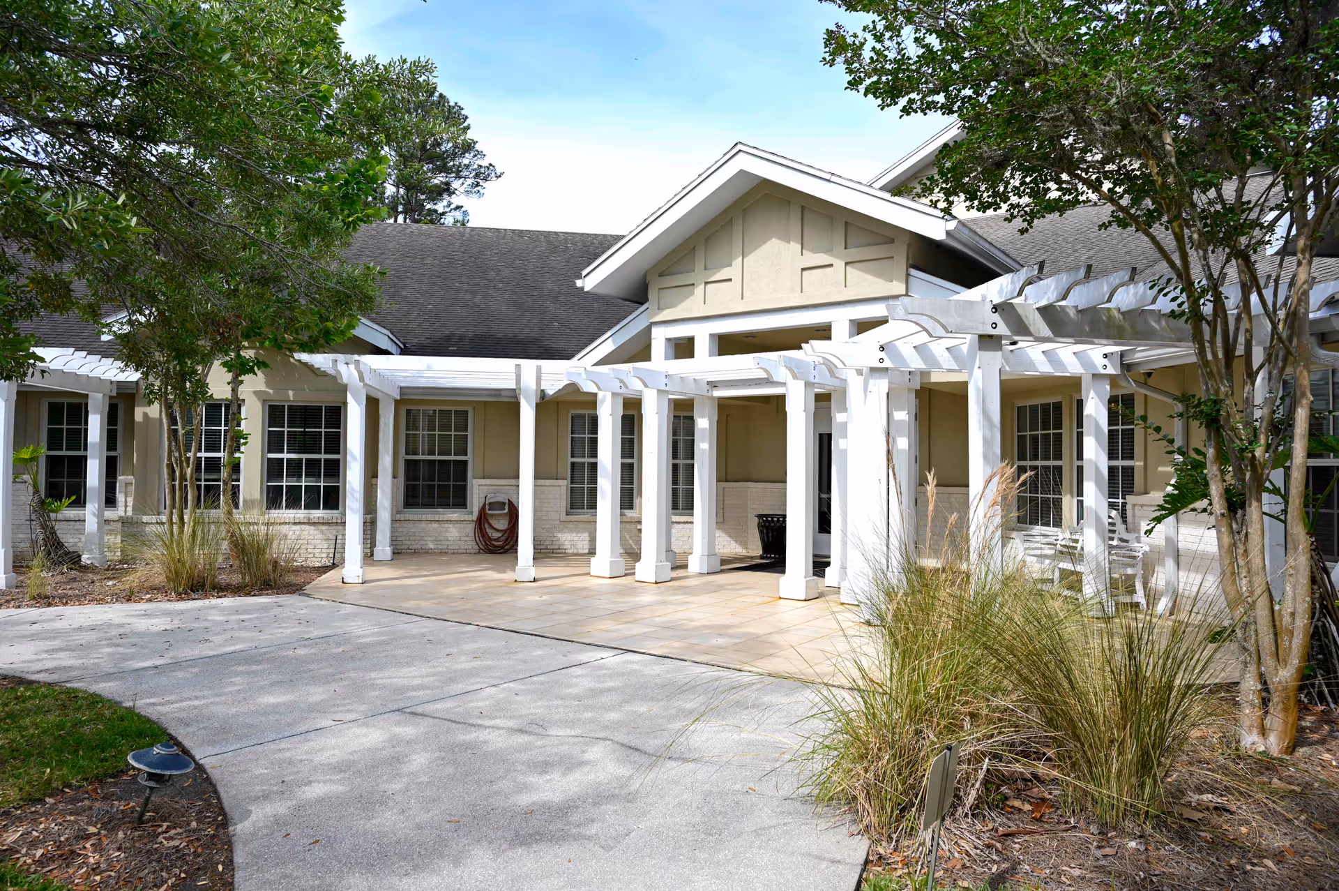 Exterior view of Alivia Care @ Home entrance with white pergola and landscaping