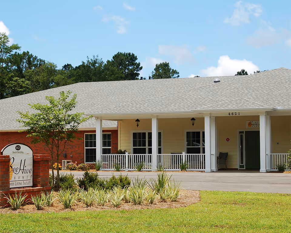 Exterior view of BeeHive Homes of Lynn Haven front entrance with porch and landscaping.