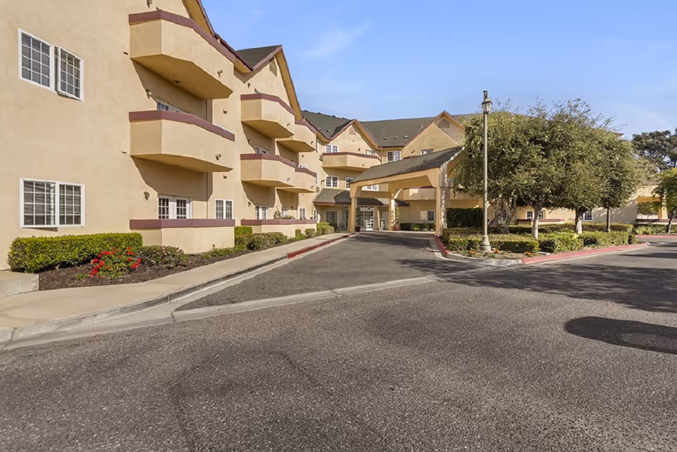 Exterior view of Merrill Gardens at Santa Maria, showing beige multi-story building and entrance.