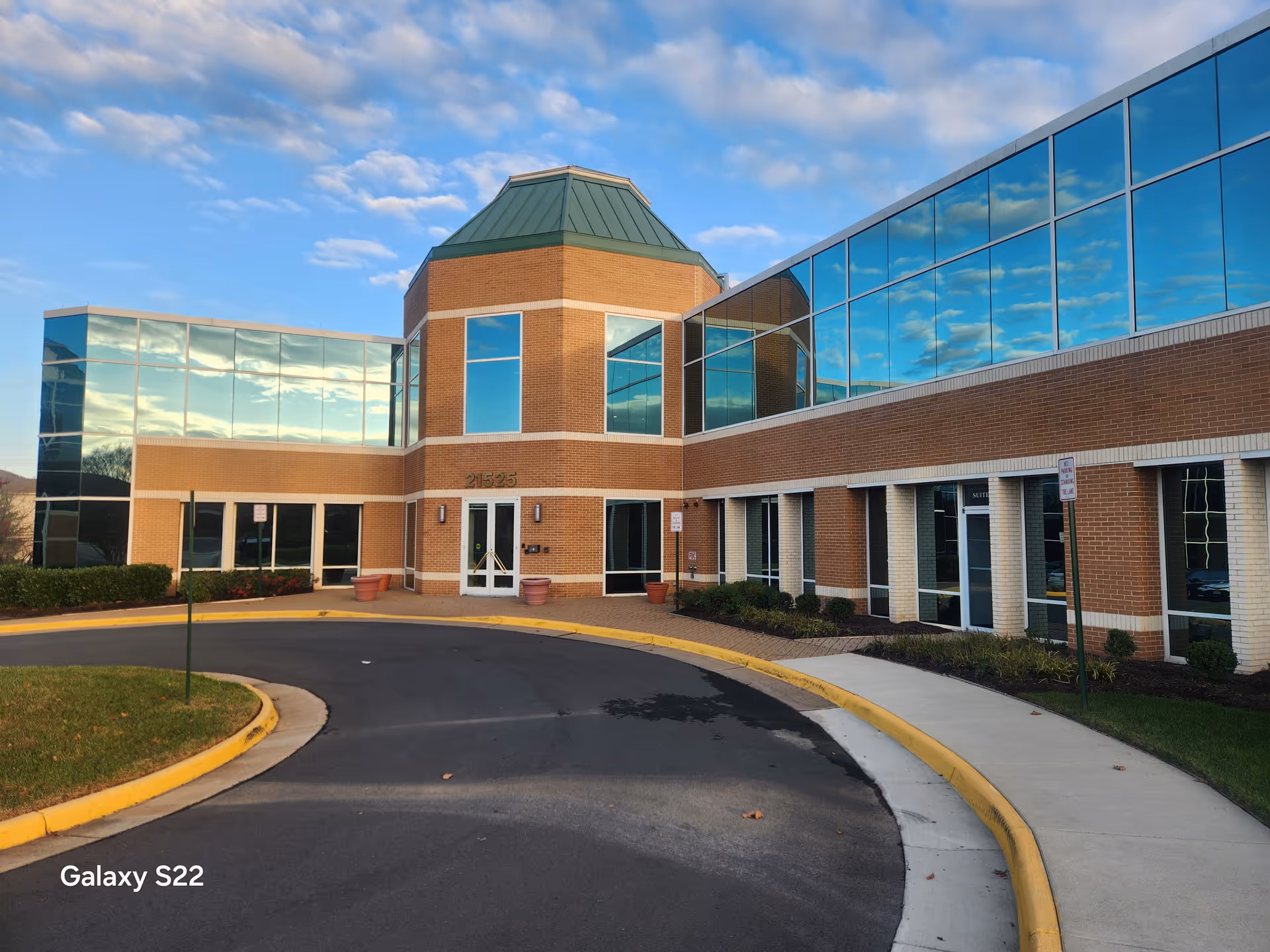 Aqua Home Health Care building exterior with brick walls, glass facade, and curved driveway.