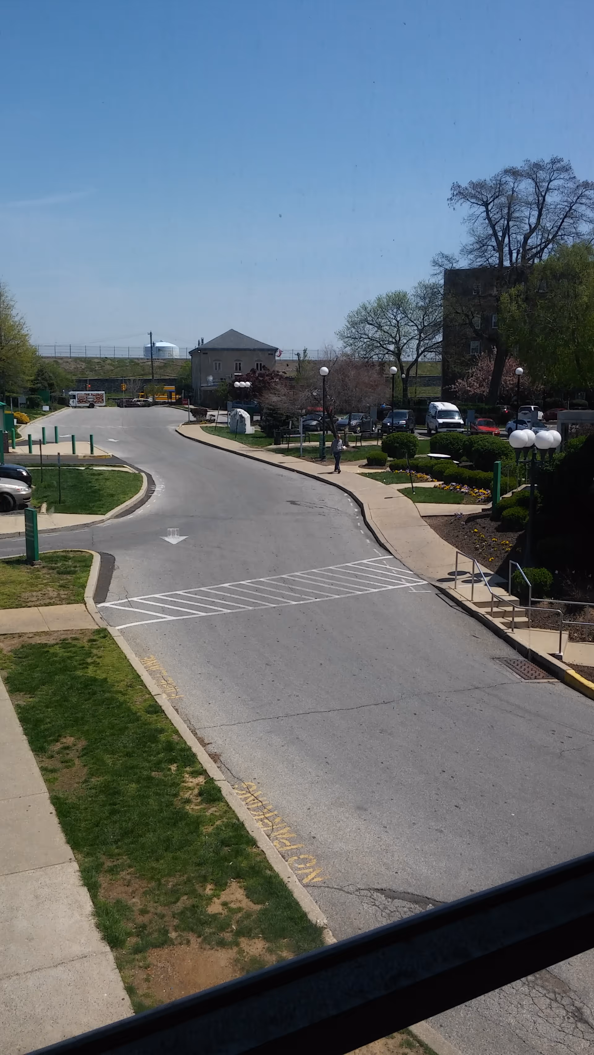 Wide campus road at Hospice of Philadelphia with trees, parking, and sidewalks.