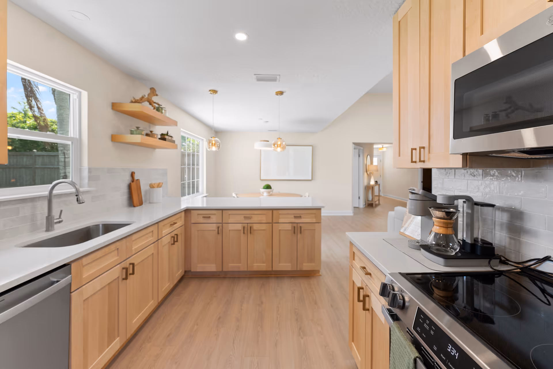 Bright, open kitchen with wooden cabinets, island, and stainless appliances.