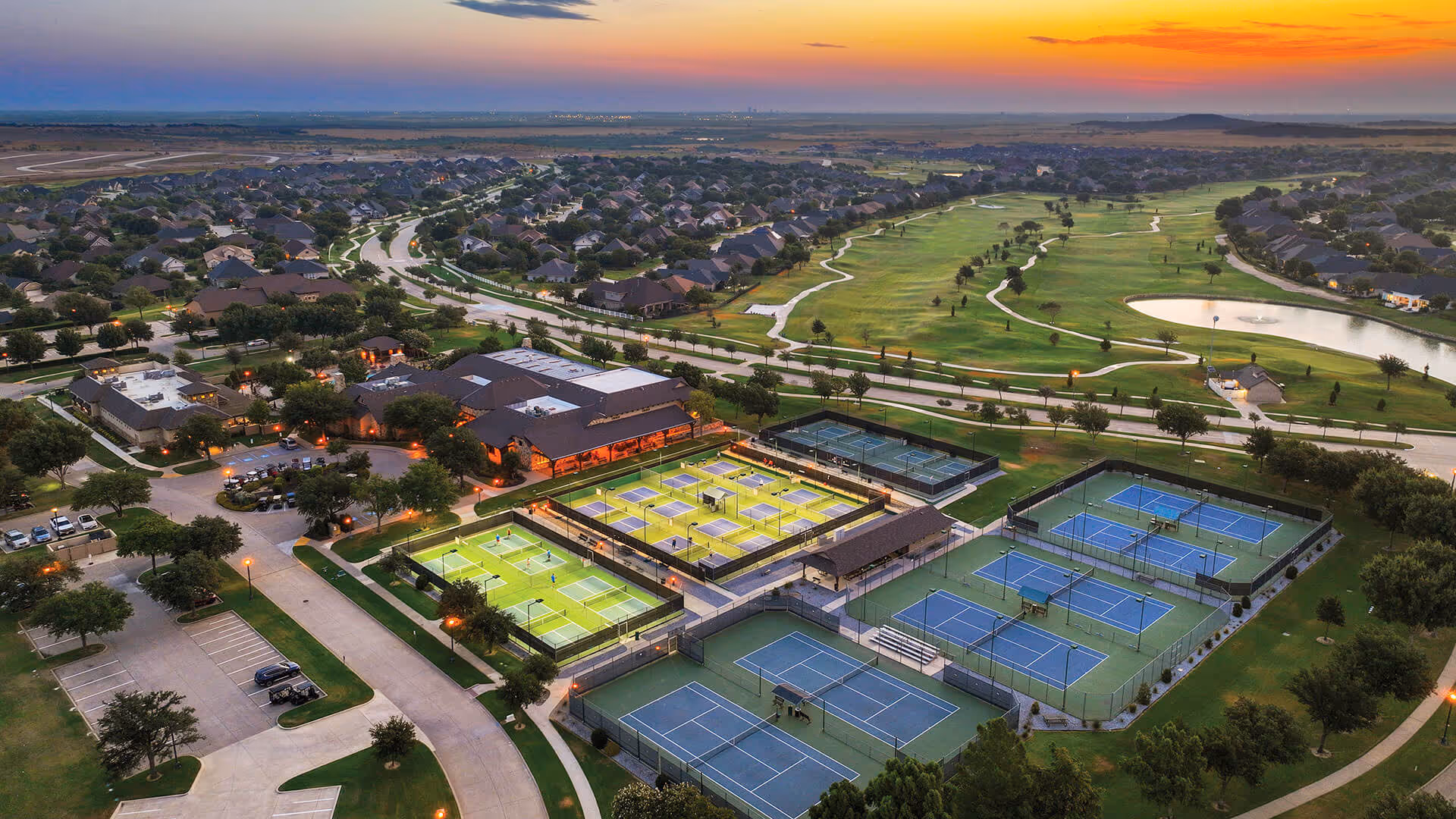Aerial view of Robson Ranch Texas community with tennis courts and surrounding homes.