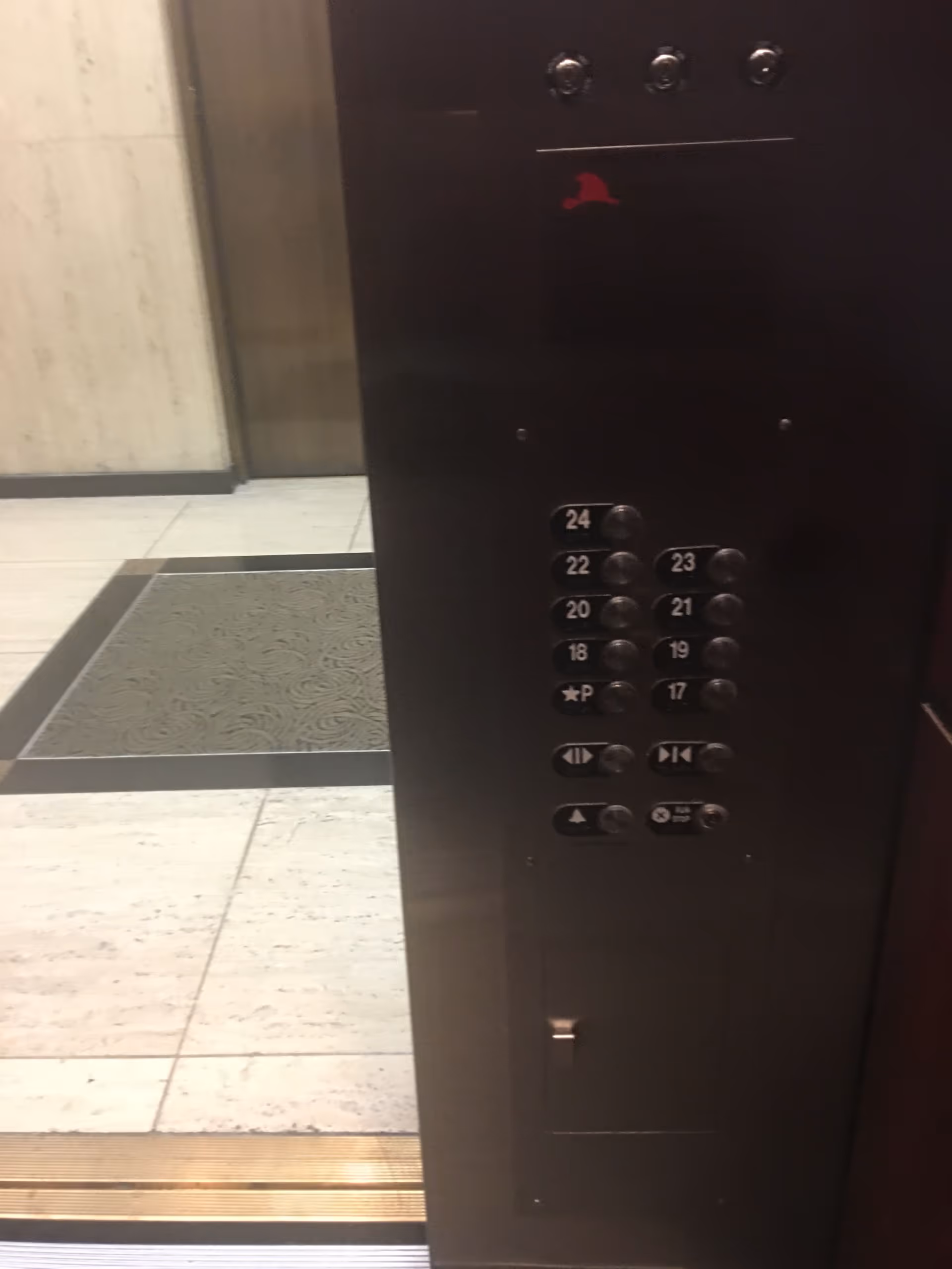 Inside an elevator, showing floor buttons and a control panel.