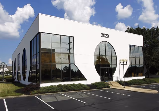 Front view of a modern white Gracelove Home Health Services building with large glass windows.
